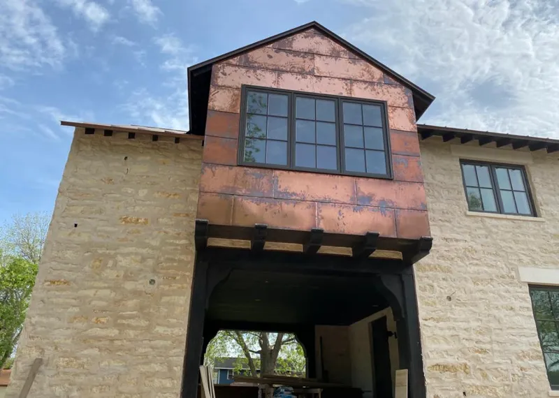 Copper metal panel facade on a stone building for Skylight Installation in Klamath Falls